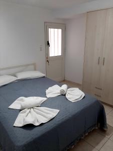 a bedroom with two white towels on a blue bed at Sitia Holidays 2 in Sitia