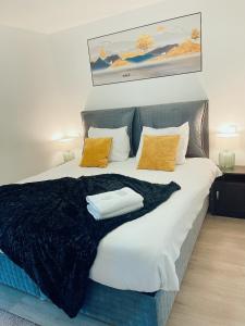 a large bed with a black blanket and yellow pillows at Hotel L'Empire in Olm