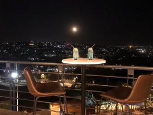 a table and chairs on a balcony at night at Mythos Boutique Hotel in Kigali