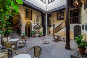 un patio con mesas, sillas y una fuente en Palacio de Mariana Pineda en Granada