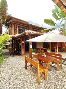 a picnic table and an umbrella in front of a building at Lalabella Itaguá in Ubatuba
