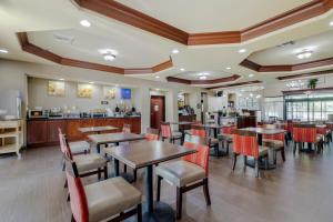 a restaurant with tables and chairs and a kitchen at Comfort Suites North Pflugerville - Austin North in Pflugerville