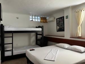two beds in a room with two bunk beds at Apartamentos Freddy's Tours in Santa Marta