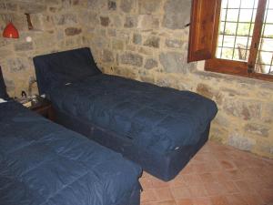 een slaapkamer met 2 bedden in een stenen muur bij Villa Degli Ulivi in Collesano