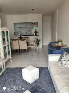 uma sala de estar com um sofá e uma mesa em Apartamento amplo a menos de 400 metros da praia localizado próximo a praça da Brunella, área nobre do Guarujá. no Guarujá