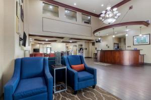 un vestíbulo con 2 sillas azules y una sala de audiencias en Comfort Suites Pflugerville - Austin North, en Pflugerville