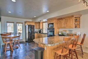 a kitchen with wooden cabinets and a island with bar stools at 2-Condo Property with Mtn Views by Golf and Ski Resort in Eden