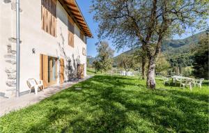 a house with a green lawn next to a building at Stunning Home In Ledro With Wifi in Ledro
