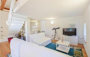 een witte slaapkamer met een wit bed en een televisie bij Gorgeous Home In Ledro With Wifi in Ledro