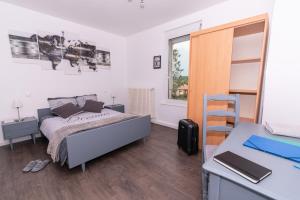 a bedroom with a bed and a desk at Private & Comfortable Apartments in Puttelange-aux-Lacs