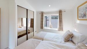 um quarto branco com uma cama e uma janela em Beech 27 Hot Tub em Garton