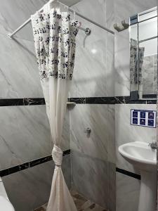 cortina de ducha en el baño con lavamanos en Apartamentos Freddy's Tours, en Santa Marta