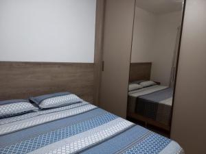 1 dormitorio con 2 camas y espejo en Lindo Apartamento em Lençóis en Lençóis