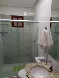 y baño con lavabo y ducha acristalada. en Lindo Apartamento em Lençóis en Lençóis