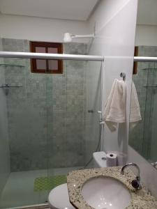 a bathroom with a sink and a glass shower at Lindo Apartamento em Lençóis in Lençóis