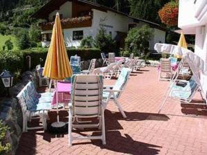 a group of lawn chairs and umbrellas on a patio at Hotel Sturpen in Sankt Leonhard im Pitztal