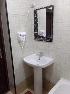 La salle de bains est pourvue d'un lavabo et d'un miroir. dans l'établissement Gavhar House, à Khiva