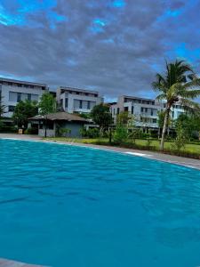 uma grande piscina azul com edifícios ao fundo em Sunny homestay PhuQuoc em Phu Quoc