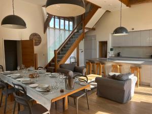 a dining room with a table and a kitchen at Batts Barn in Edenbridge