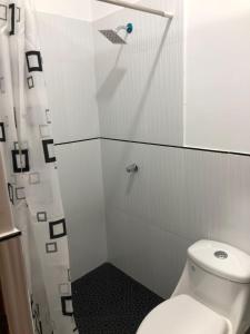 a bathroom with a toilet and a shower at CASA SHILCAYO Habitaciones Vacacionales in Tarapoto