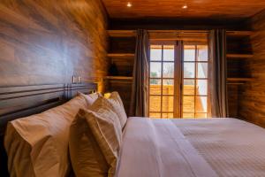 1 dormitorio con cama y ventana grande en Foresta Atacama Lodge, en San Pedro de Atacama