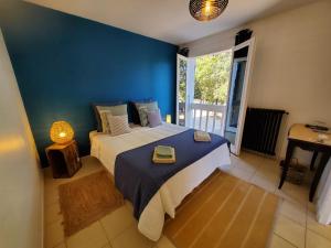 um quarto com uma cama grande e uma parede azul em LA FONTAINE AU LOUP em Saint-Maurice-sur-Eygues