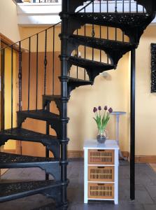 una scala a chiocciola nera con un vaso di fiori su un tavolo di Town center duplex with lift a Clonakilty