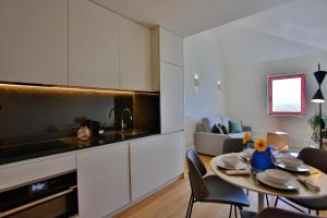 a kitchen and living room with a table and chairs at 4CITY FLAT CAMARÃO in Porto