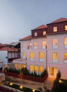 a large pink building with its lights on at 4CITY FLAT CAMARÃO in Porto