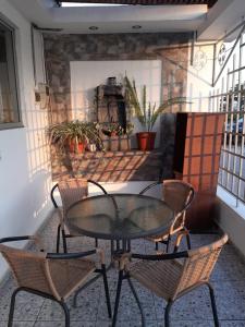 a glass table and chairs on a patio at Hostal D' Silvia in Arica
