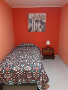 um quarto vermelho com uma cama e uma fotografia na parede em Hostal D' Silvia em Arica