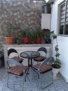 una mesa y dos sillas y una mesa y algunas plantas en Hostal D' Silvia en Arica