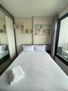 a bedroom with a large white bed and a window at The Base in pattaya in Pattaya Central