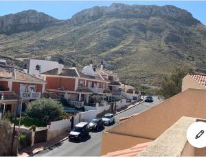 eine Stadt mit Autos auf einer Straße mit einem Berg in der Unterkunft Adosado cerca de la playa y club de buceo con piscina en calabardina, Aguilas in Calabardina