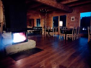 a living room with a fireplace and a table and chairs at Villa Beskid in Milówka