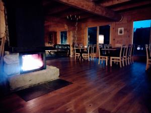 sala de estar con chimenea, mesa y sillas en Villa Beskid, en Milówka