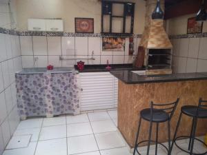 a kitchen with two chairs and a counter with a stove at Casa Pra temporada in Aparecida