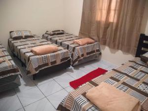 a room with three beds in a room at Casa Pra temporada in Aparecida