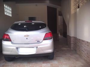 a white car is parked in a garage at Casa Pra temporada in Aparecida