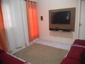 a living room with a flat screen tv on the wall at Casa Pra temporada in Aparecida