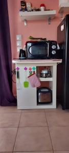a small toy kitchen with a microwave on a counter at Anastacias Apartment in Artemida