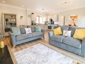 a living room with two couches and a kitchen at Avenue Croft in Nottingham