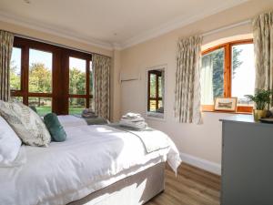 a bedroom with a large white bed and windows at Avenue Croft in Nottingham