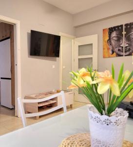 una sala de estar con un jarrón con flores sobre una mesa en Apartamento Marily, en Córdoba