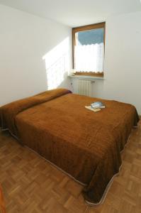um quarto com uma cama com um cobertor castanho em Casa Anselmi em Croviana