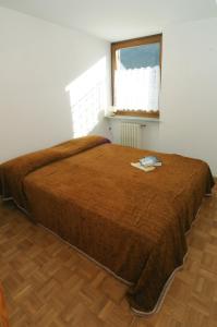 a bedroom with a bed with a brown blanket at Casa Anselmi in Croviana