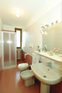 bagno con 2 servizi igienici, lavandino e doccia di Casa Anselmi a Croviana