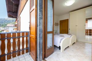 a bedroom with a bed and a balcony at [Presolana Home] relax con vista - SELF CHECK IN in Castione della Presolana
