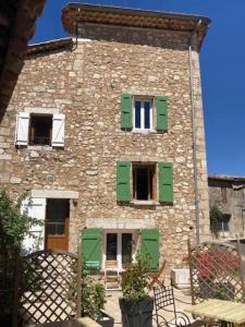 a large stone building with green shutters on it at Charming house village for 6 people in Baudinard