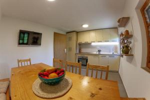a kitchen with a wooden table with a bowl of fruit on it at Andy's Holiday Home with HotTub & Sauna 